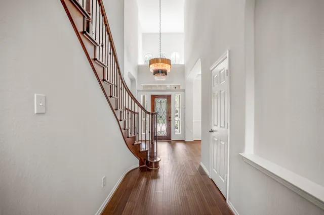 a view of a hallway with wooden floor and staircase