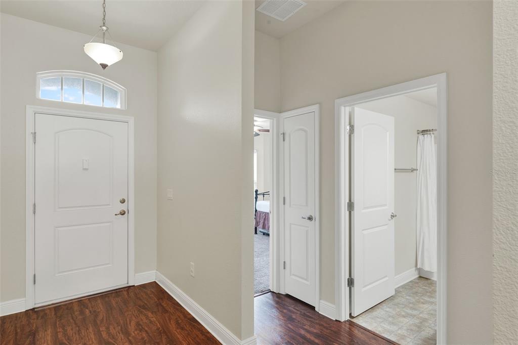 4229 Barnsley Lane Tavares, FL 32778 - Photo 2 of 20 an empty room with wooden floor cabinet and front door