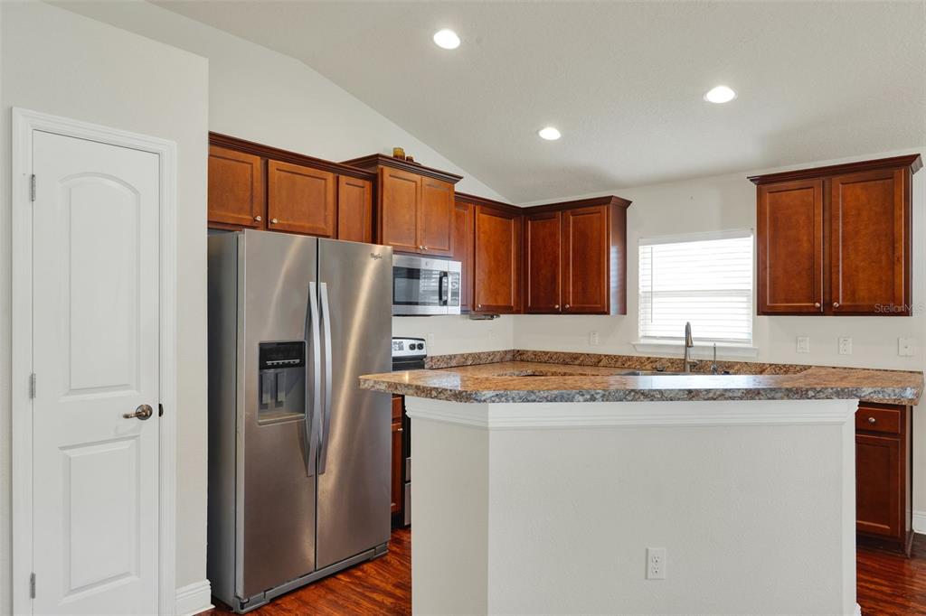 4229 Barnsley Lane Tavares, FL 32778 - Photo 9 of 20 a kitchen with stainless steel appliances granite countertop a refrigerator and a sink