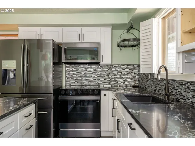 a kitchen with stainless steel appliances granite countertop a sink stove and refrigerator