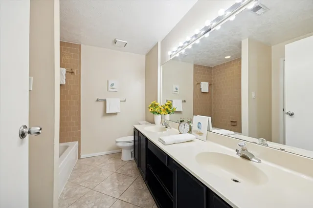 an empty room with windows and ceiling fan