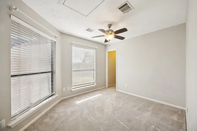 a bed sitting in a spacious bedroom next to a window