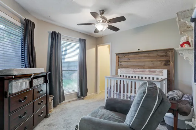 a spacious bedroom with a bed and a chandelier
