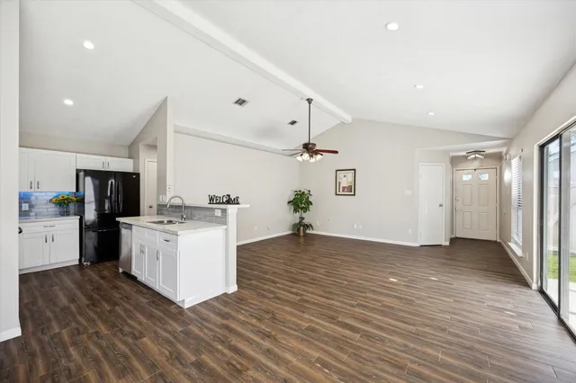 an empty room with windows and ceiling fan