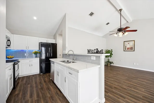 a view of a livingroom with a ceiling fan and wooden floor