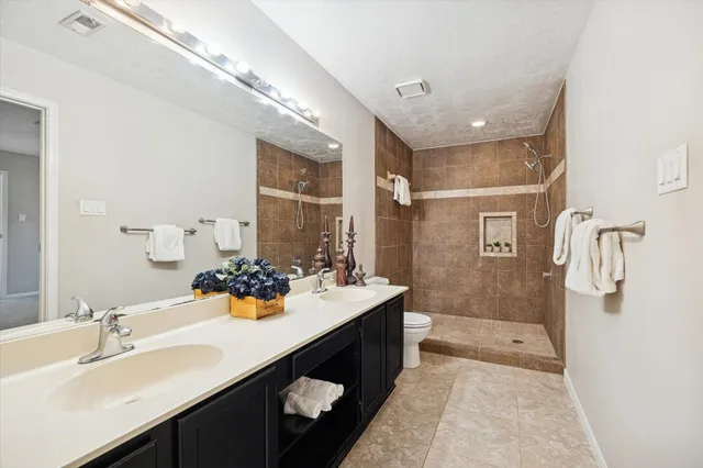 a bedroom with a large bed and a chandelier fan