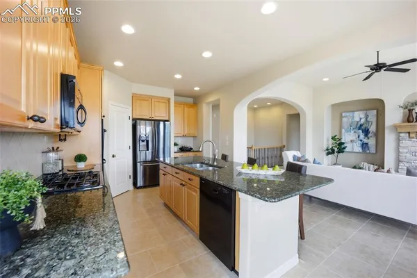 a kitchen with stainless steel appliances granite countertop sink stove and refrigerator