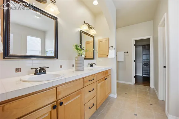 a spacious bathroom with double sink and a mirror
