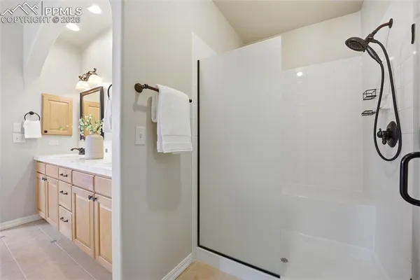 a bathroom with a double vanity sink a mirror and a shower