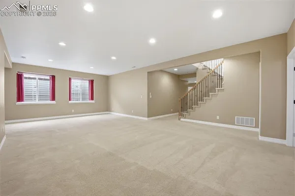 a view of an empty room with window and stairs