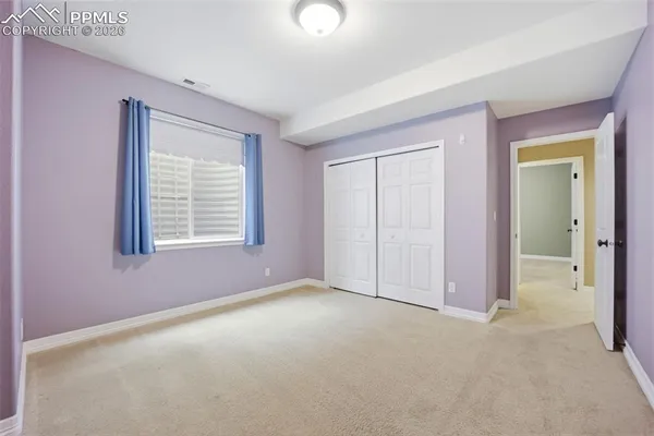an empty room with windows and closet