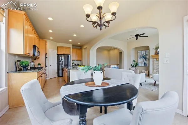 a dining room with wooden floor a chandelier a wooden table and chairs