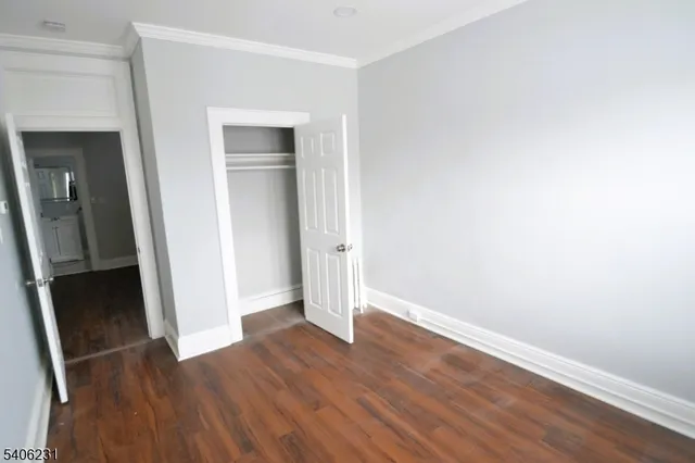 an empty room with wooden floor and closet