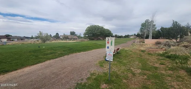a view of a road with a big yard and palm trees