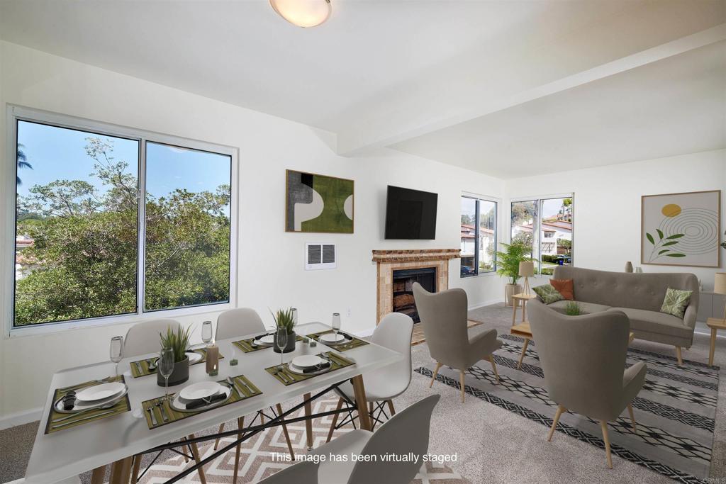 930 Via Mil Cumbres, Unit 52 Solana Beach, CA 92075 - Photo 1 of 34 a living room with furniture a flat screen tv and a fireplace