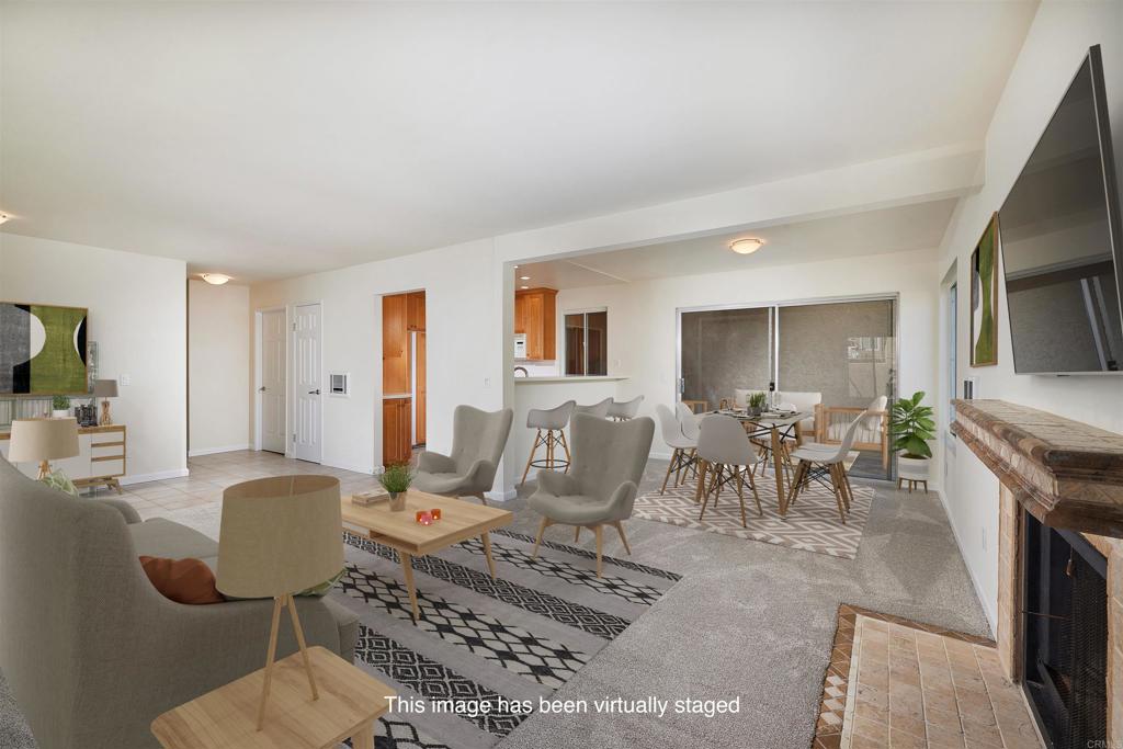 930 Via Mil Cumbres, Unit 52 Solana Beach, CA 92075 - Photo 17 of 34 a living room with furniture a flat screen tv and a fireplace