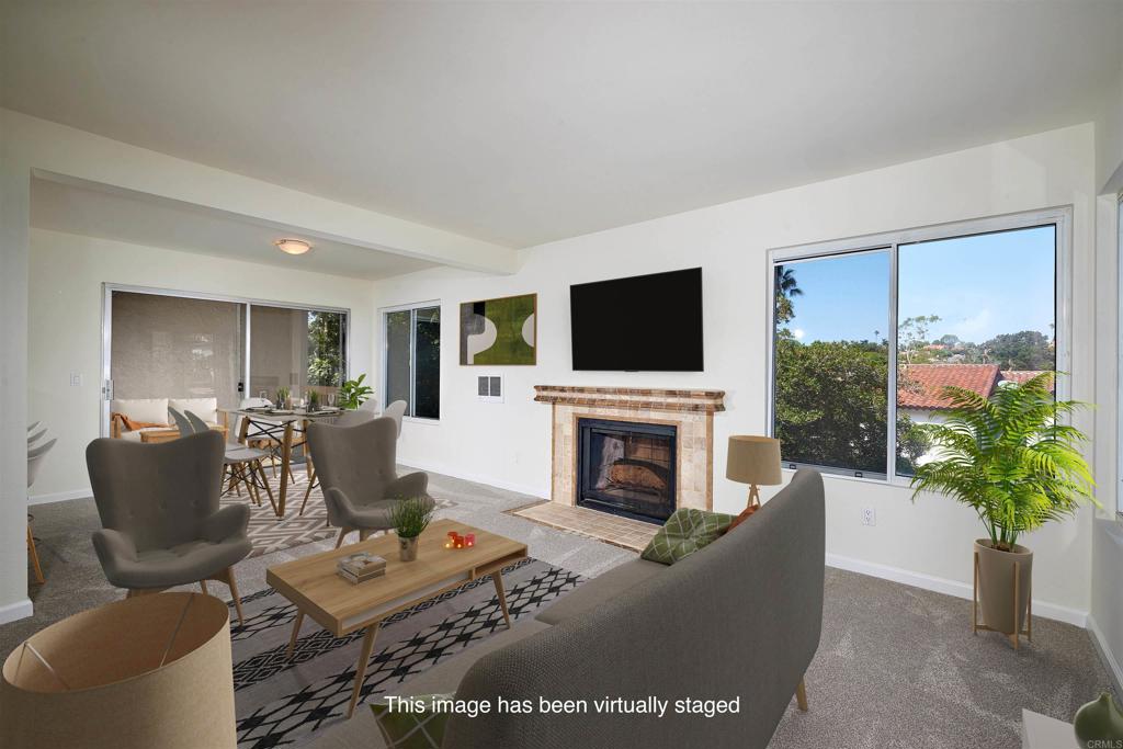 930 Via Mil Cumbres, Unit 52 Solana Beach, CA 92075 - Photo 18 of 34 a living room with furniture a flat screen tv and a fireplace