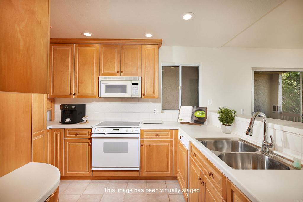 930 Via Mil Cumbres, Unit 52 Solana Beach, CA 92075 - Photo 20 of 34 a kitchen with a sink a stove and refrigerator