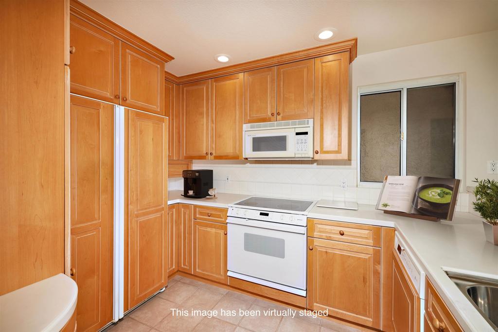 930 Via Mil Cumbres, Unit 52 Solana Beach, CA 92075 - Photo 21 of 34 a kitchen with stainless steel appliances a stove a sink and a refrigerator