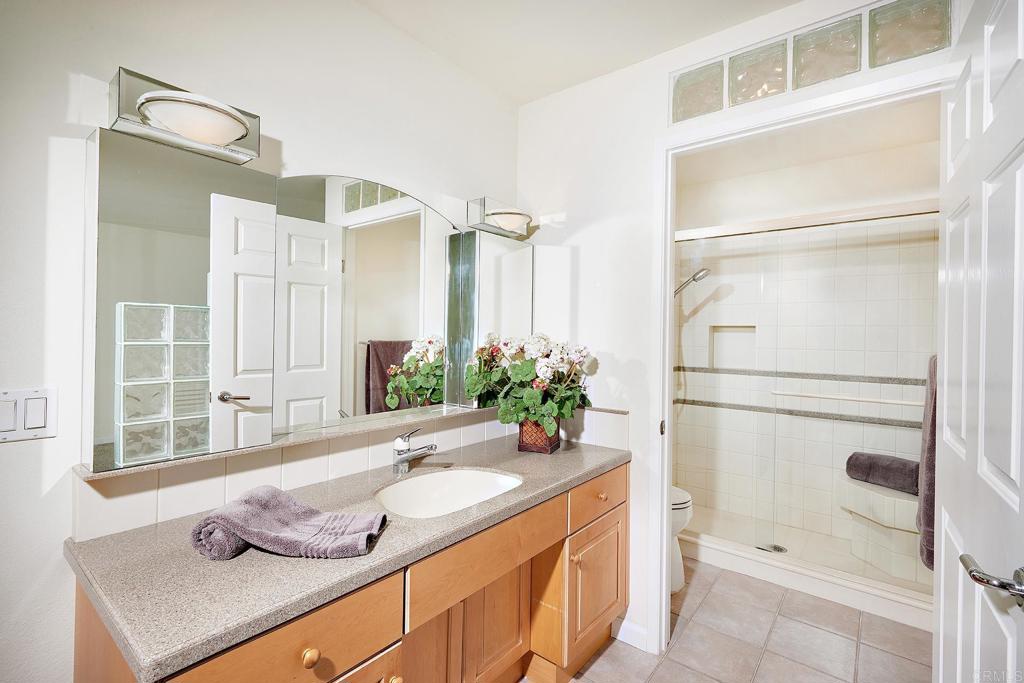 930 Via Mil Cumbres, Unit 52 Solana Beach, CA 92075 - Photo 24 of 34 a bathroom with a granite countertop sink and a mirror