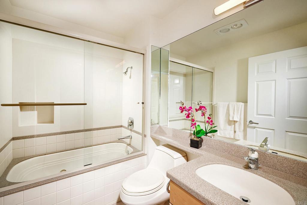 930 Via Mil Cumbres, Unit 52 Solana Beach, CA 92075 - Photo 26 of 34 a bathroom with a granite countertop sink a toilet and shower