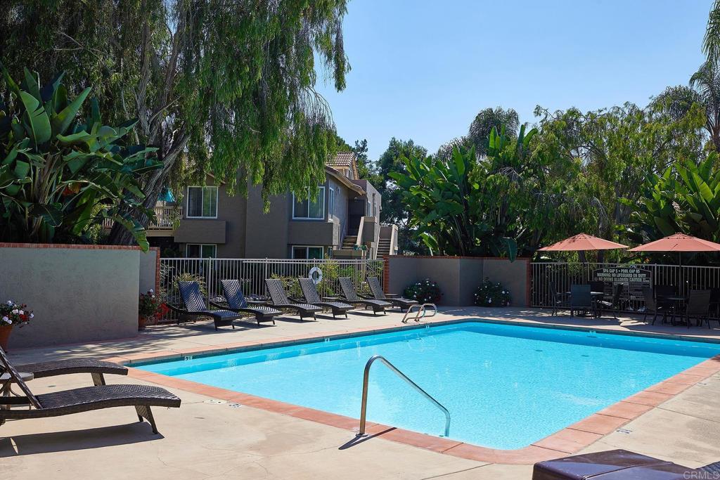 930 Via Mil Cumbres, Unit 52 Solana Beach, CA 92075 - Photo 32 of 34 a view of a swimming pool with lawn chairs under an umbrella