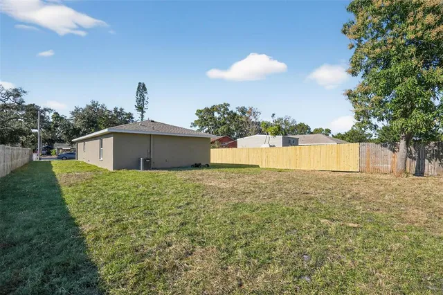 a view of a house with a backyard and a tree