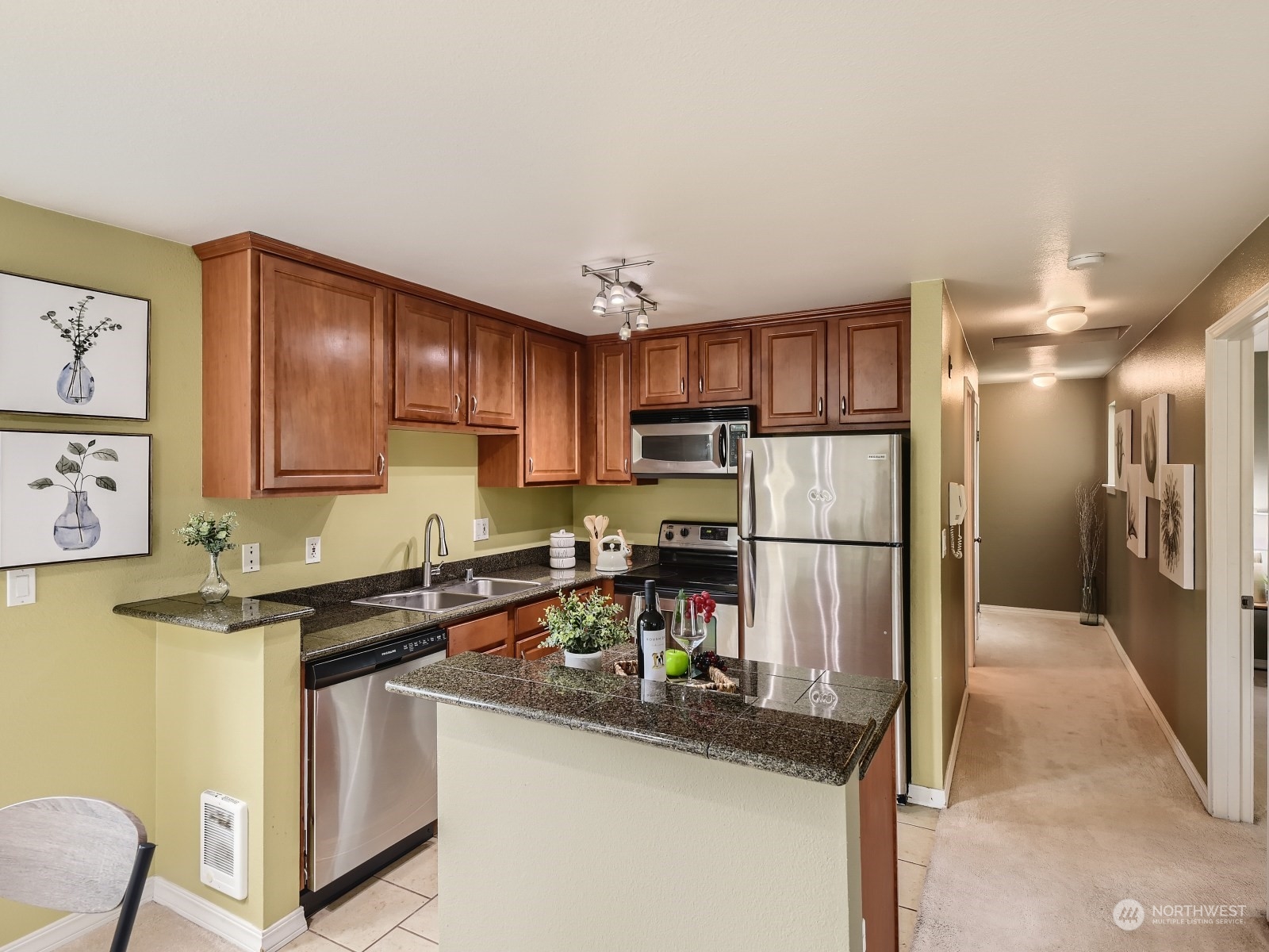 20328 Bothell Everett Highway, Unit B304 Bothell, WA 98012 - Photo 9 of 27 a kitchen with stainless steel appliances granite countertop a refrigerator a stove a sink and a microwave