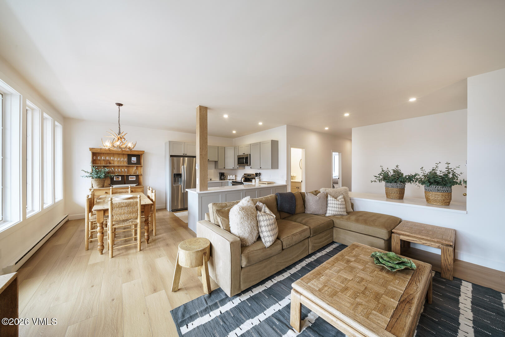 a living room with furniture and a dining table with wooden floor