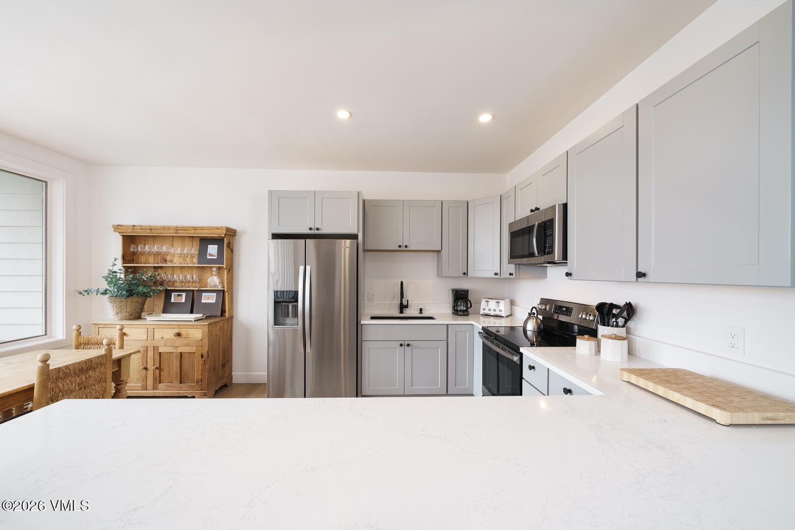 625 North Frontage Road West, Unit 32B Vail, CO 81657 - Photo 7 of 34 a kitchen with a refrigerator a stove top oven a sink a dining table and chairs