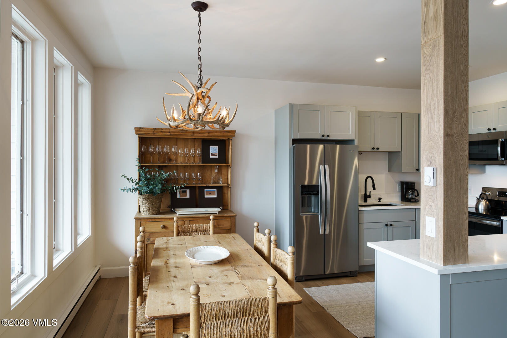 625 North Frontage Road West, Unit 32B Vail, CO 81657 - Photo 10 of 34 a kitchen with stainless steel appliances granite countertop a refrigerator a sink dishwasher a dining table and chairs with wooden floor