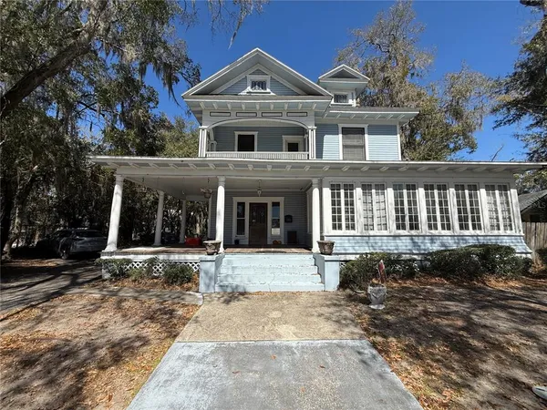 a front view of a house with a yard and outdoor seating