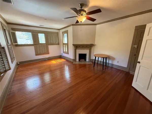 a view of a livingroom with wooden floor and a fireplace
