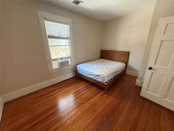 a living room with wooden floor and window