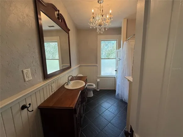 a bathroom with a sink a large mirror and a toilet