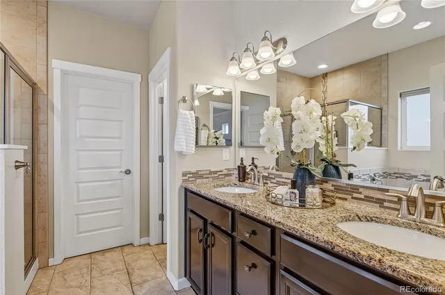 a bathroom with a granite countertop sink double vanity and a mirror