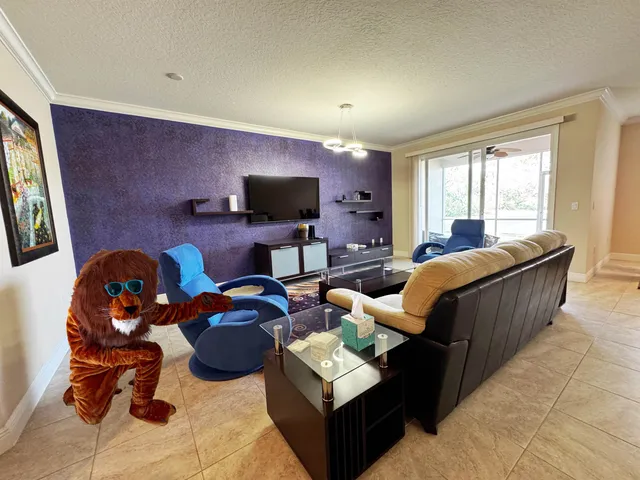 a living room with furniture a flat screen tv and a window