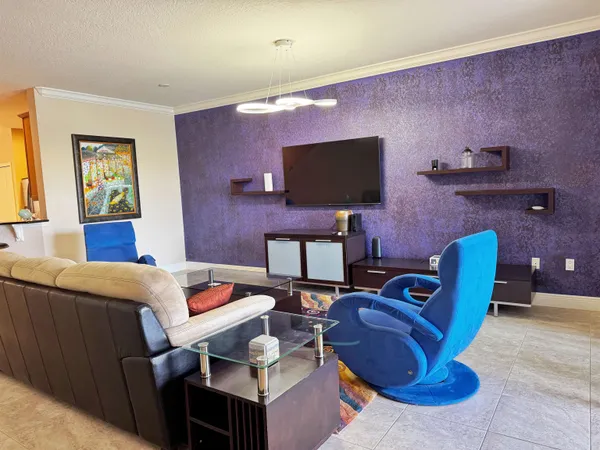 a living room with furniture a flat screen tv and a fireplace
