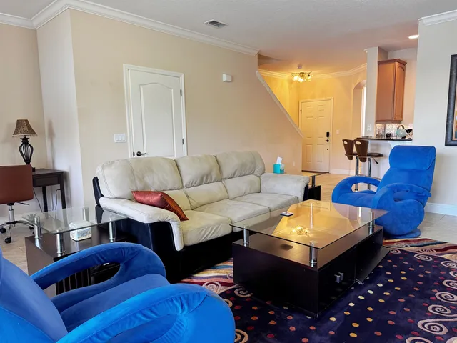 a living room with furniture a rug and a chandelier