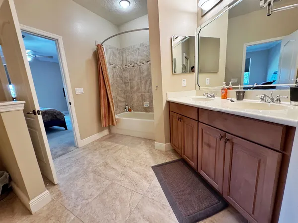 a bathroom with double vanity sink a mirror and a shower