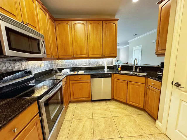 a kitchen with stainless steel appliances granite countertop a stove a sink and a microwave