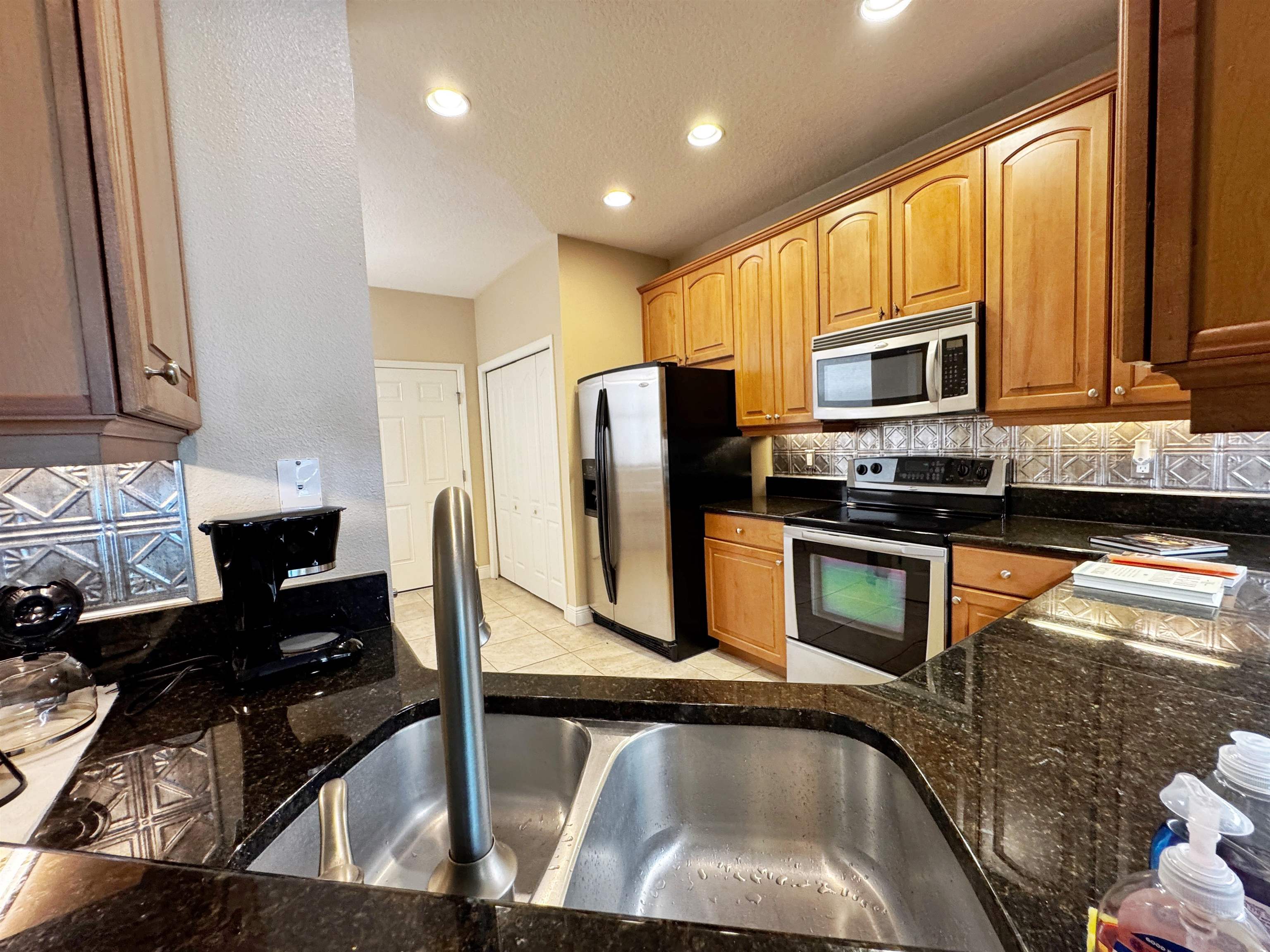 80 Riverview Bend South, Unit 814 Palm Coast, FL 32137 - Photo 7 of 39 a kitchen with stainless steel appliances granite countertop a refrigerator a stove top oven a sink and dishwasher