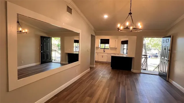 a view of empty room with wooden floor fireplace and window