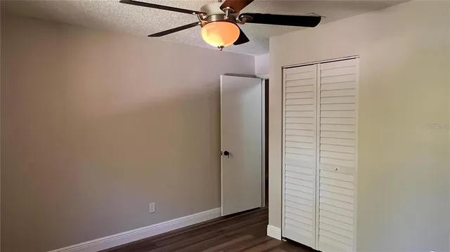 an empty room with a window and a fan