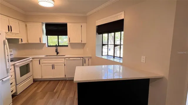 a kitchen with kitchen island a sink appliances and cabinets