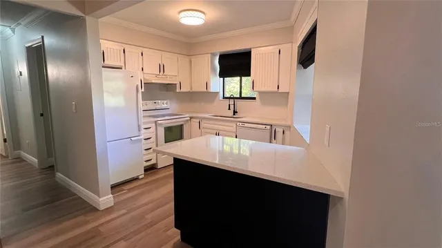 a kitchen with white cabinets sink and white appliances