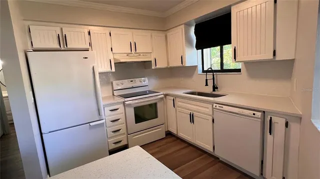 a kitchen with white cabinets and white appliances