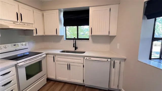 a kitchen with a sink window and cabinets