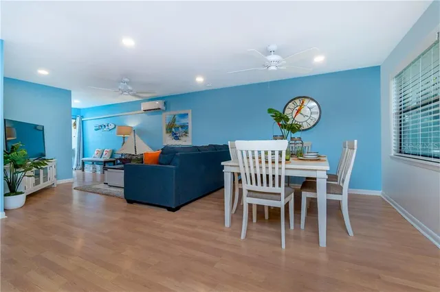 a living room with furniture a dining table and a large window