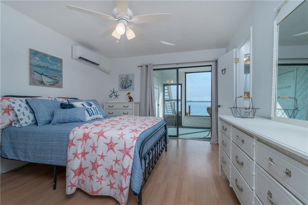 5041 North Beach Road, Unit 3B Englewood, FL 34223 - Photo 18 of 55 a spacious bedroom with two beds and a chandelier